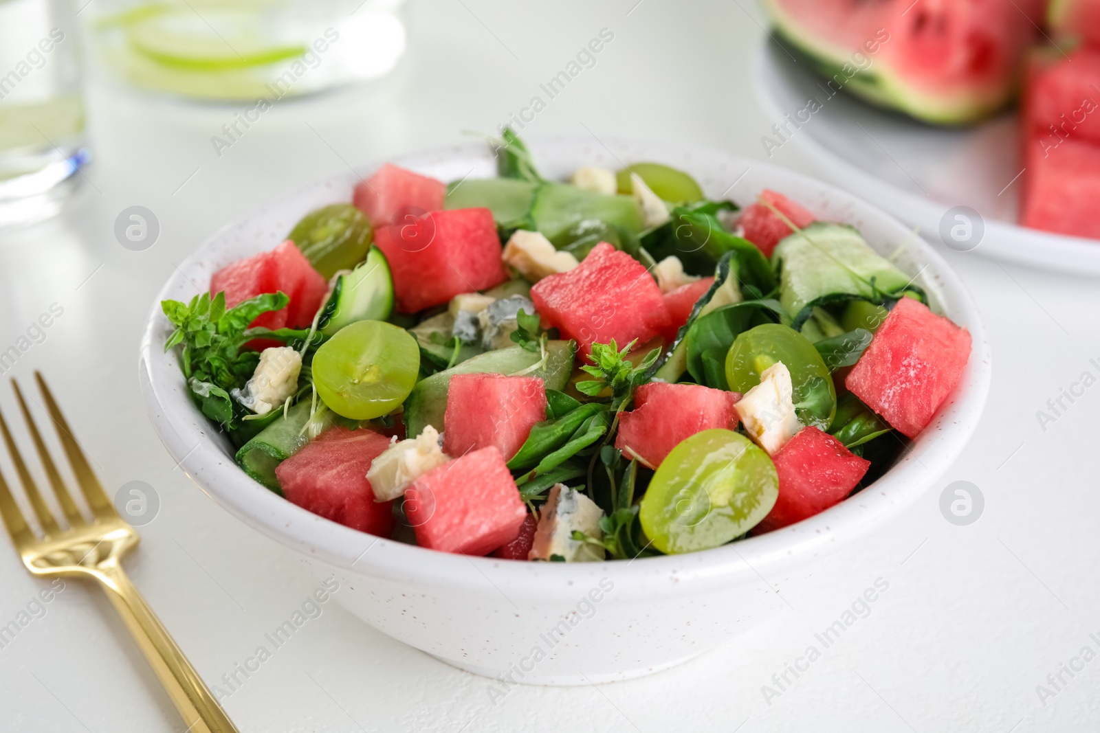 Photo of Delicious salad with watermelon served on white table, closeup