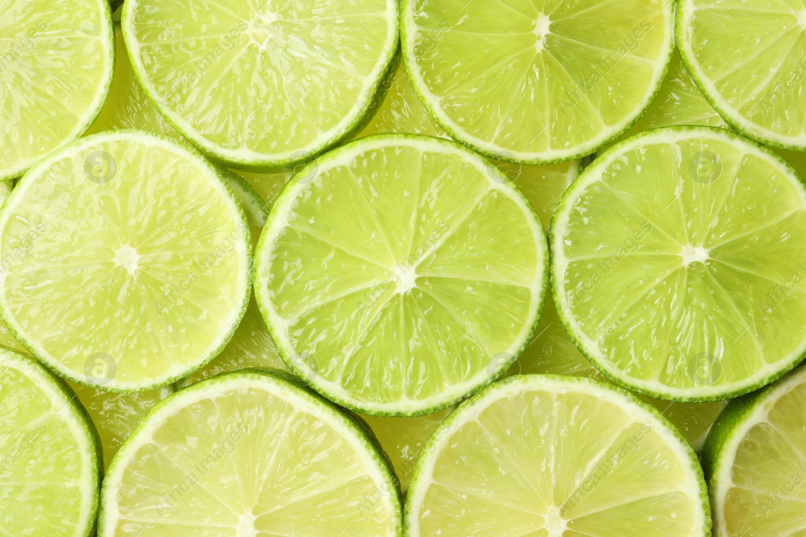 Photo of Fresh juicy lime slices as background, top view