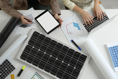 Photo of Architects working on house project with solar panels at white table, top view. Alternative energy source