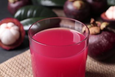 Delicious fresh mangosteen juice in glass on table, closeup view