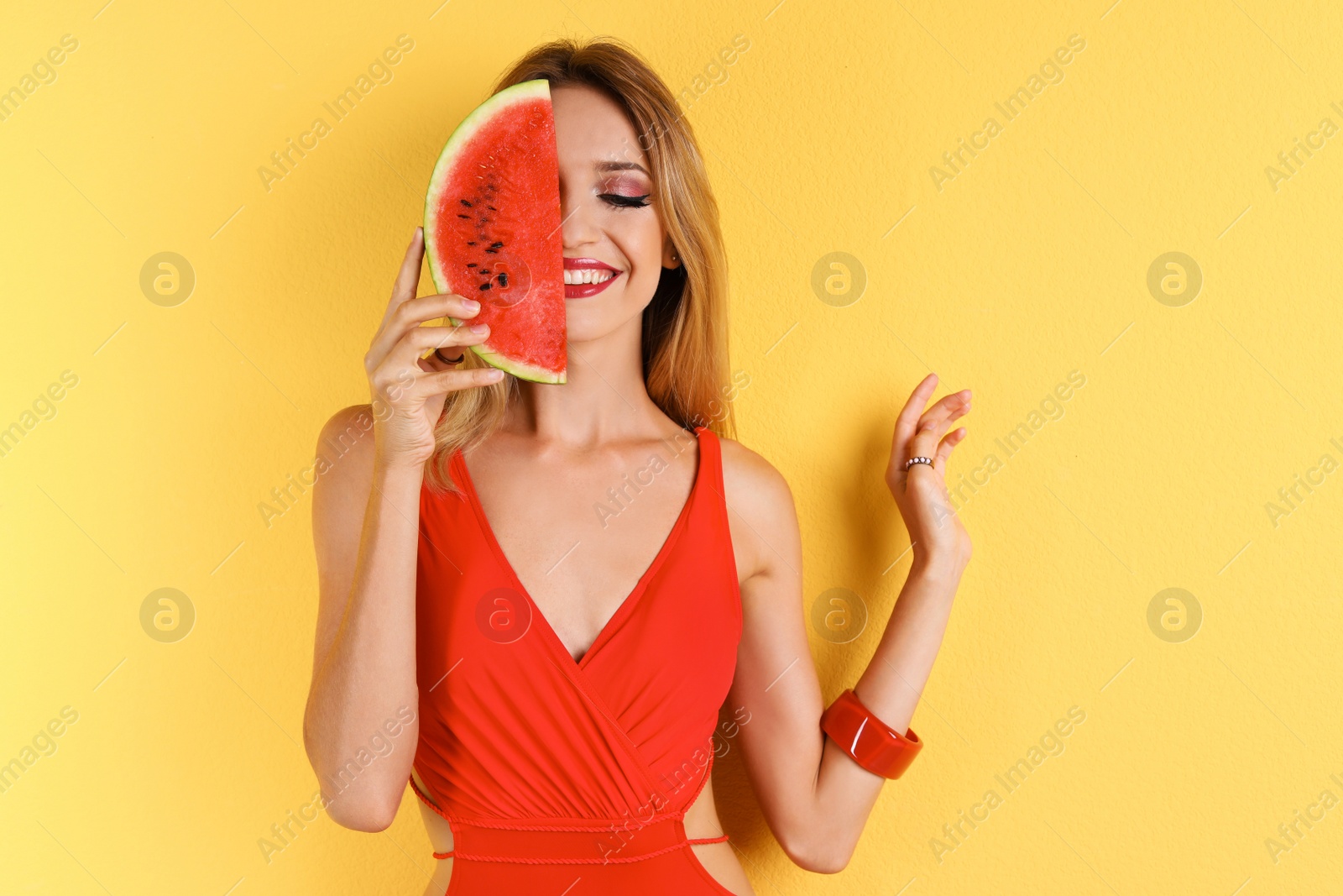 Photo of Pretty young woman with juicy watermelon on color background