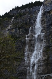 Photo of Picturesque view of beautiful mountain waterfall with moss outdoors