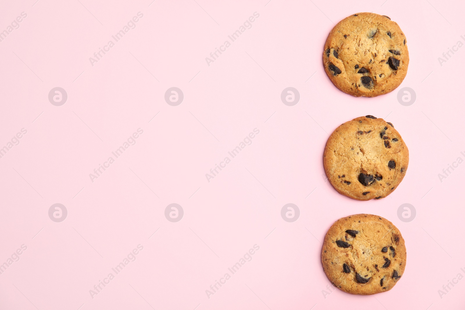 Photo of Delicious chocolate chip cookies on color background, flat lay. Space for text