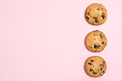 Photo of Delicious chocolate chip cookies on color background, flat lay. Space for text