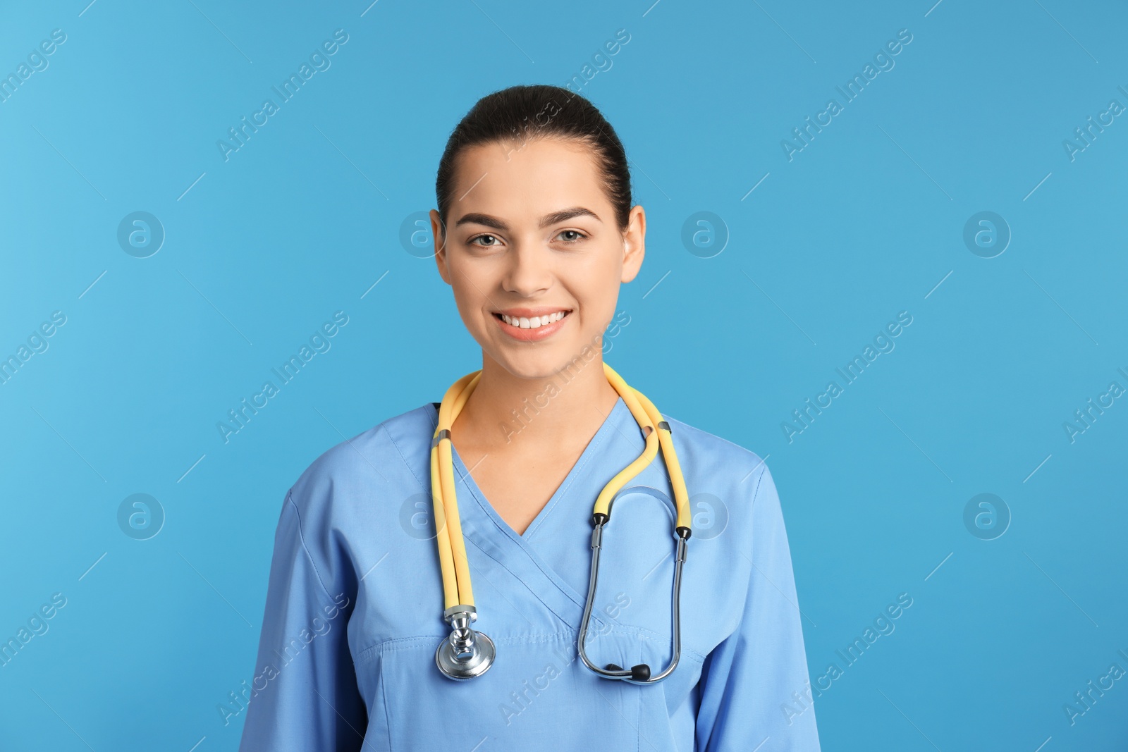 Photo of Portrait of young medical assistant with stethoscope on color background