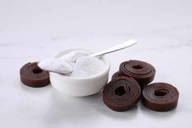 Photo of Sweet fructose powder and fruit leather rolls on white table