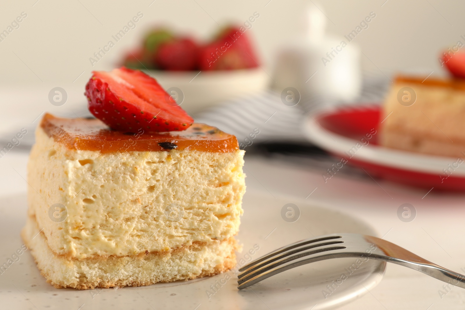 Photo of Piece of cheesecake with strawberry and fork on table, closeup