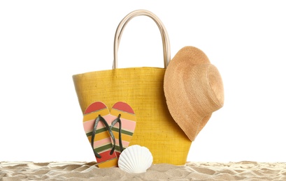 Photo of Stylish yellow bag and beach accessories on sand against white background