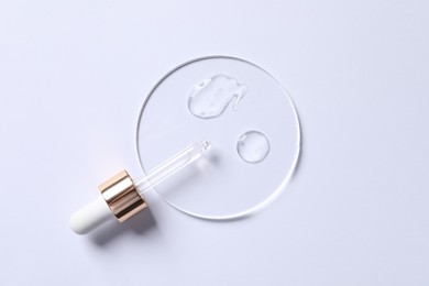 Photo of Samples of cosmetic serum and pipette on white background, top view