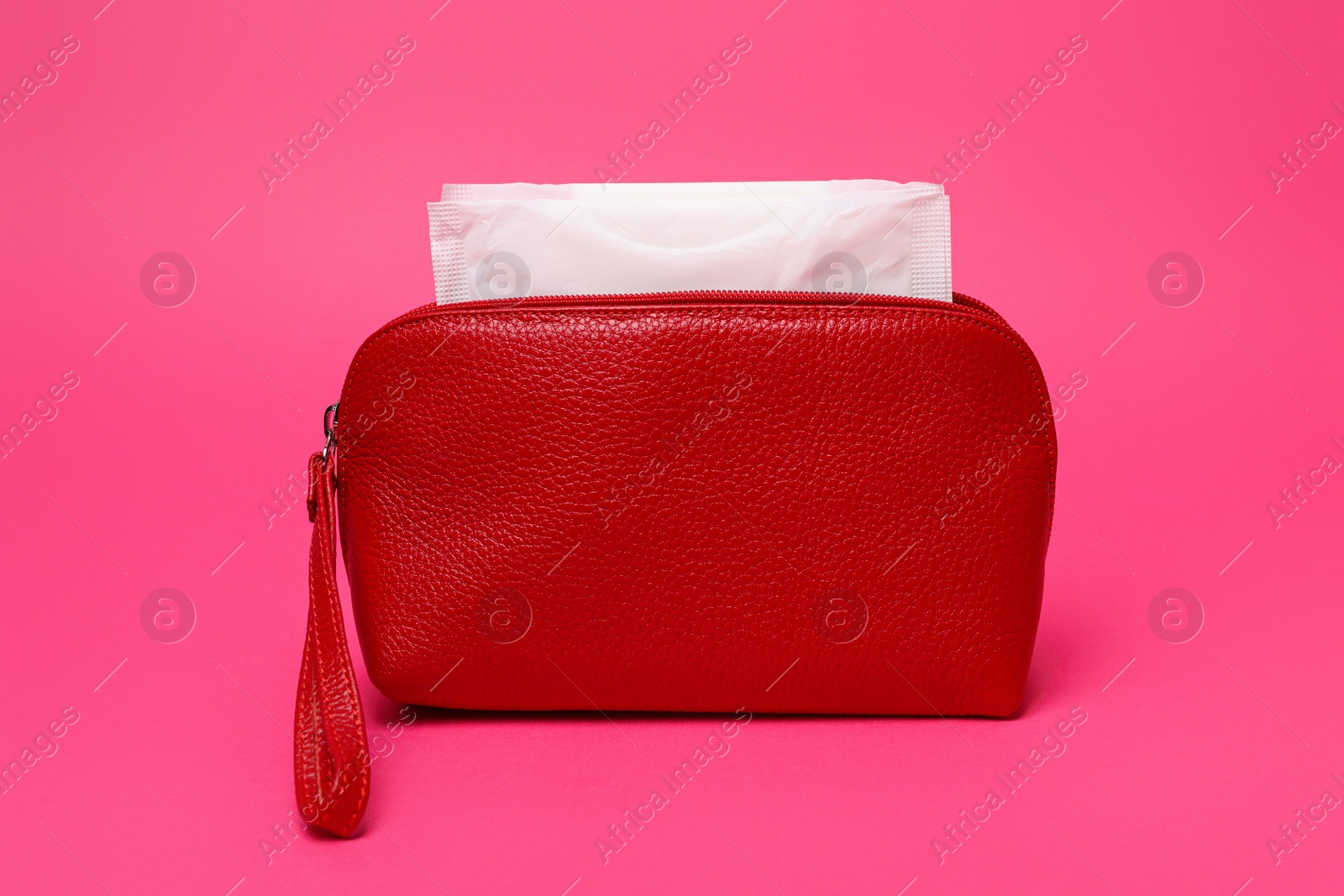 Photo of Red bag with menstrual pads on pink background