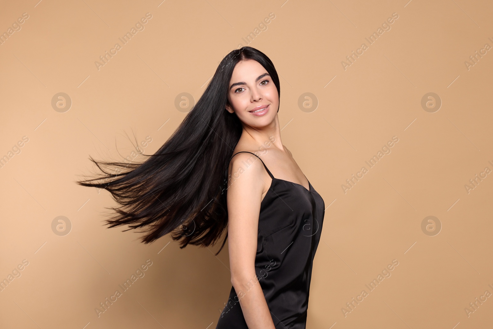 Photo of Portrait of beautiful young woman with healthy strong hair on beige background