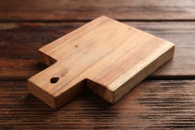 Photo of One new cutting board on wooden table, closeup