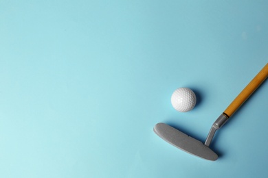 Photo of Golf ball and club on light blue background, flat lay. Space for text