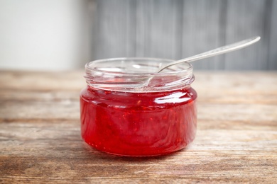 Photo of Jar with sweet jam on wooden table