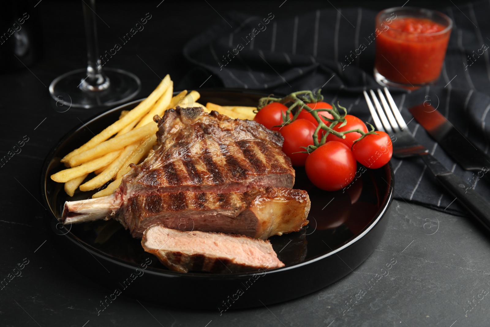 Image of Tasty grilled steak served on black table 