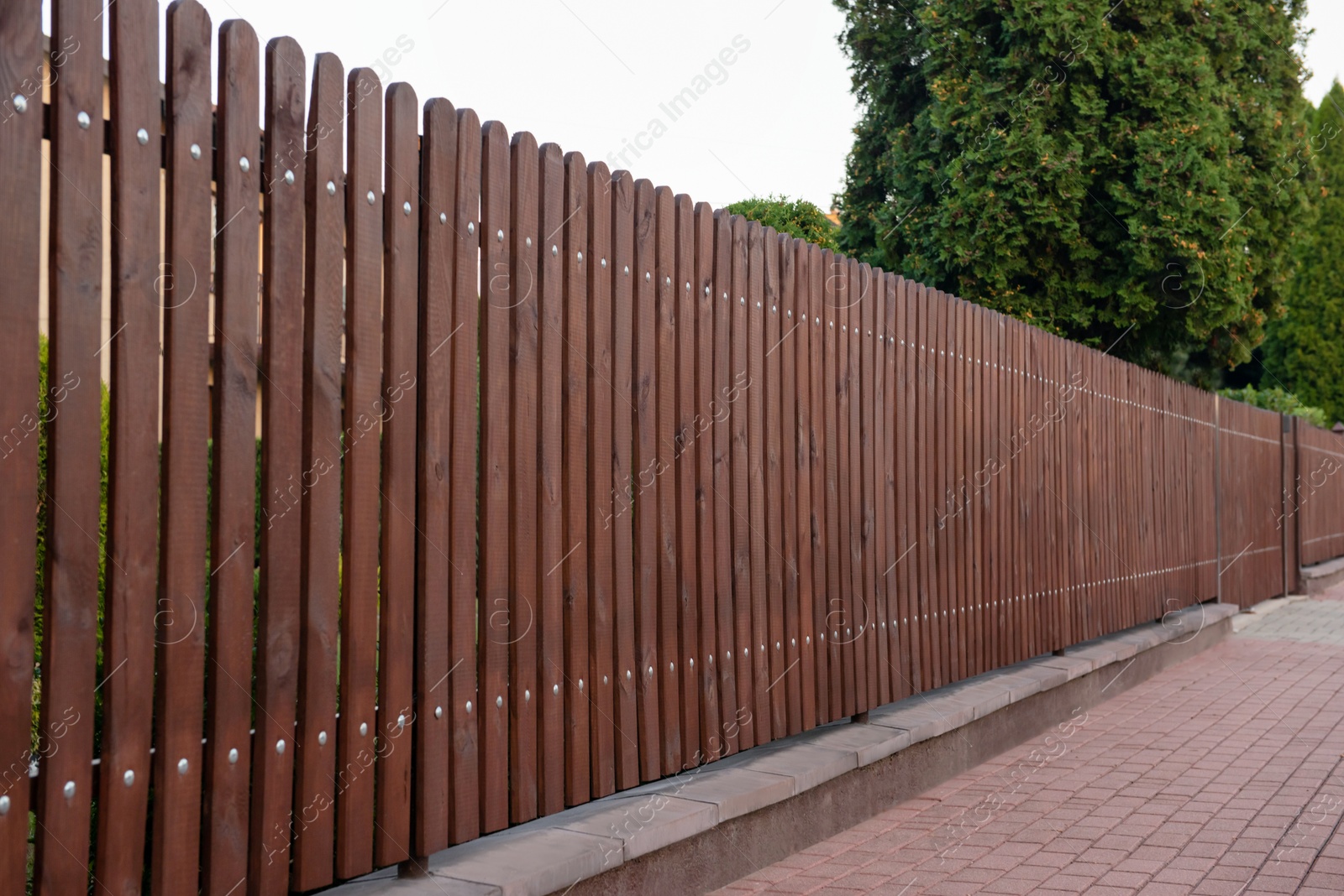 Photo of Beautiful wooden fence and trees near pathway outdoors