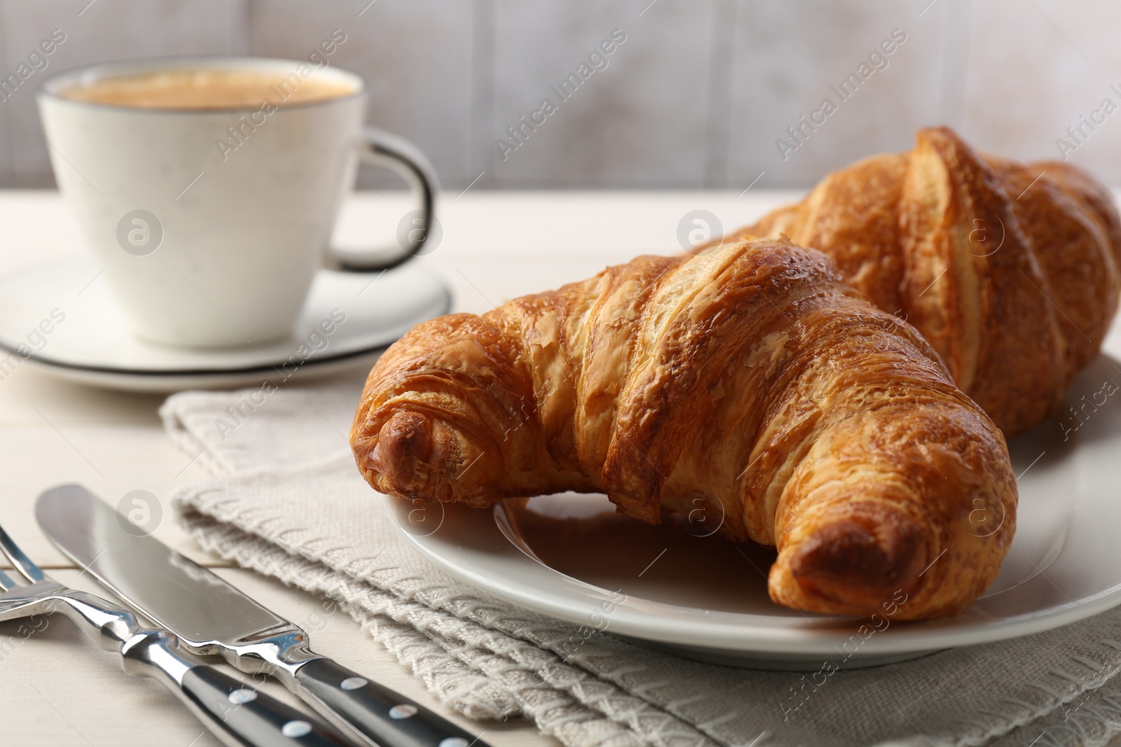 Photo of Delicious fresh croissants served on table, closeup