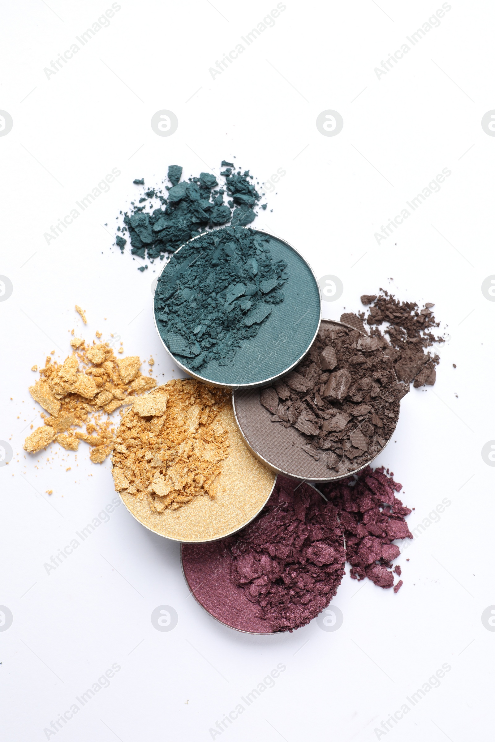 Photo of Different crushed eye shadows on white background, flat lay. Professional makeup product