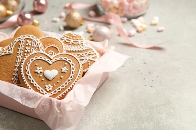 Photo of Tasty heart shaped gingerbread cookies and festive decor on light table. Space for text