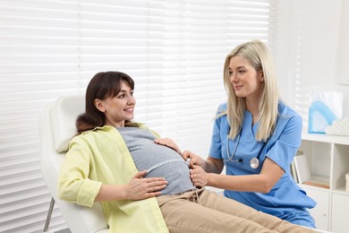 Pregnancy checkup. Doctor measuring patient's tummy in clinic