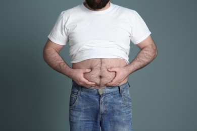 Overweight man on color background