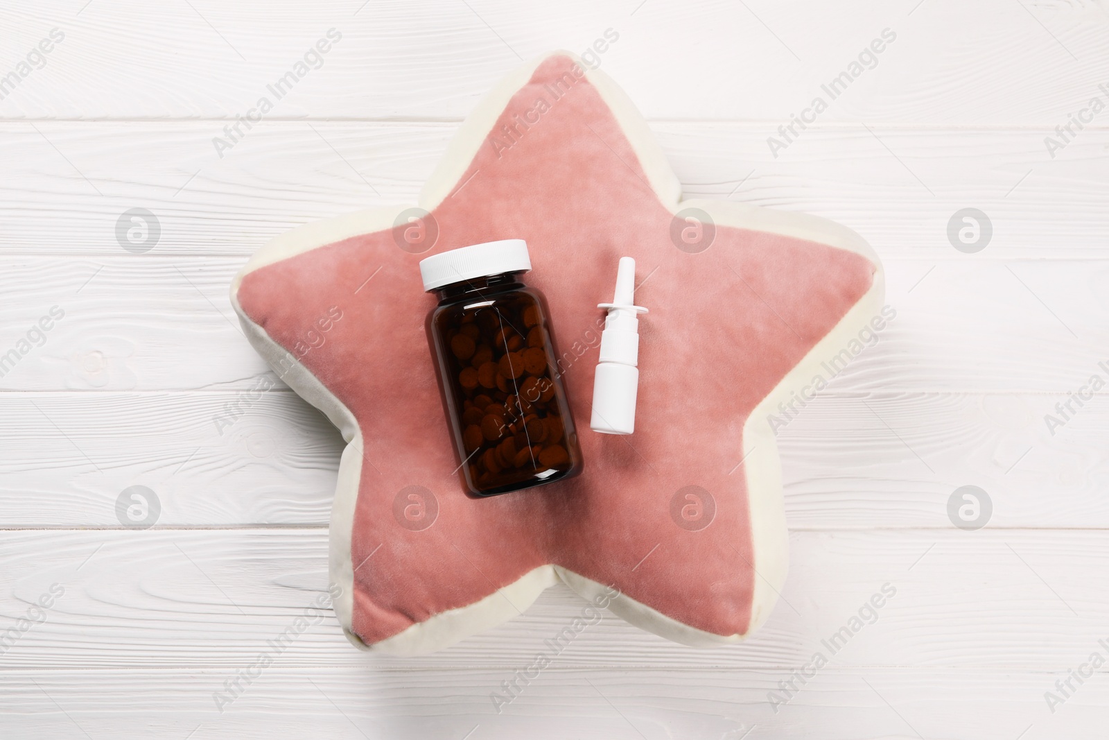 Photo of Pillow, pills and nasal spray on white wooden background, top view