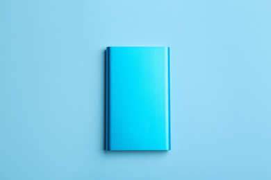 Photo of Modern external portable charger on light blue background, top view