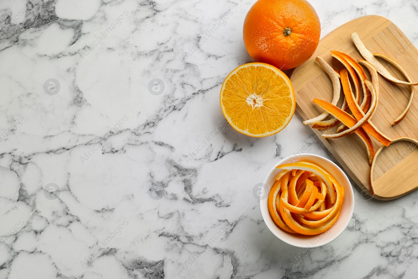 Photo of Orange fruits with peels on white marble table, flat lay. Space for text