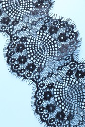 Photo of Black lace on light blue background, top view