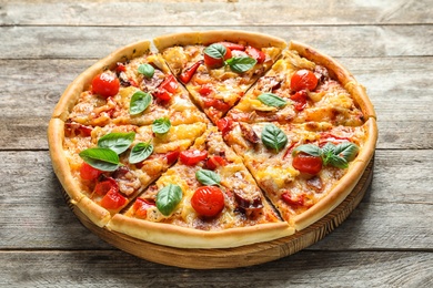 Photo of Delicious pizza with tomatoes and sausages on wooden table