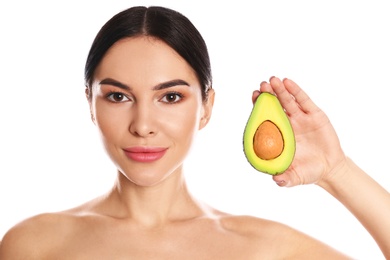 Young woman with silky skin after face mask holding avocado on white background
