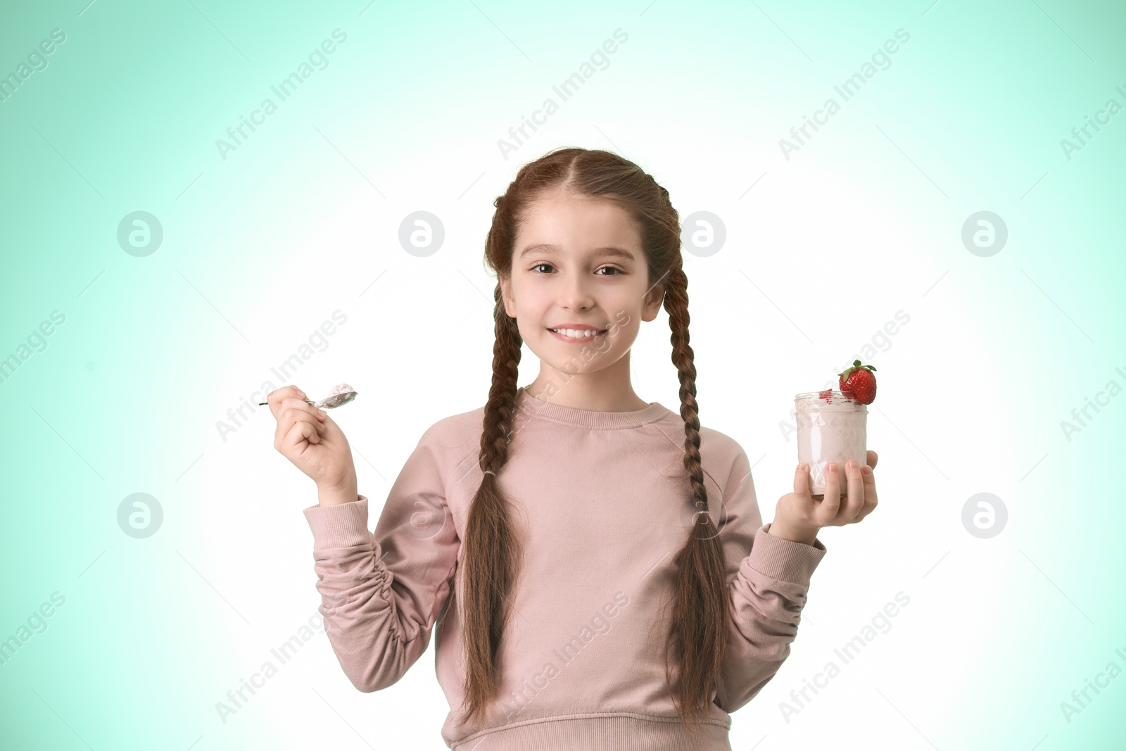 Photo of Cute girl eating tasty yogurt on color background