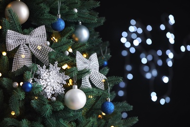 Photo of Beautiful Christmas tree with decor against blurred lights on background