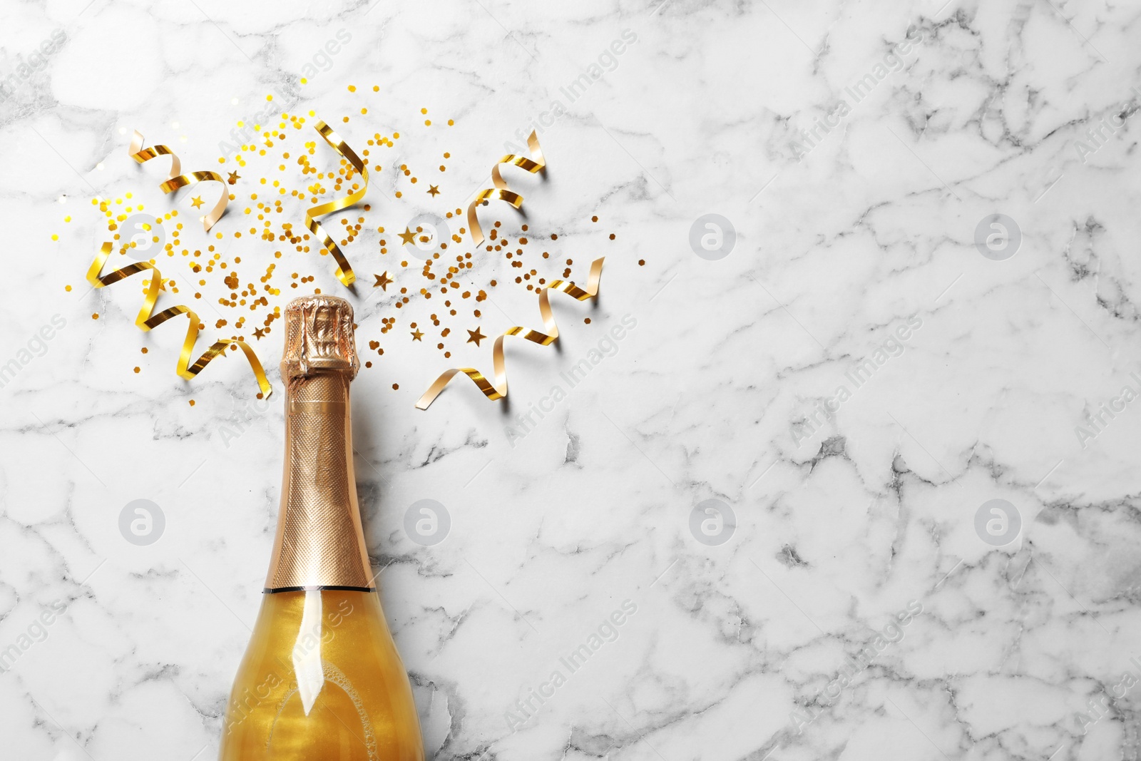 Photo of Flat lay composition with bottle of champagne for celebration on white marble background. Space for text