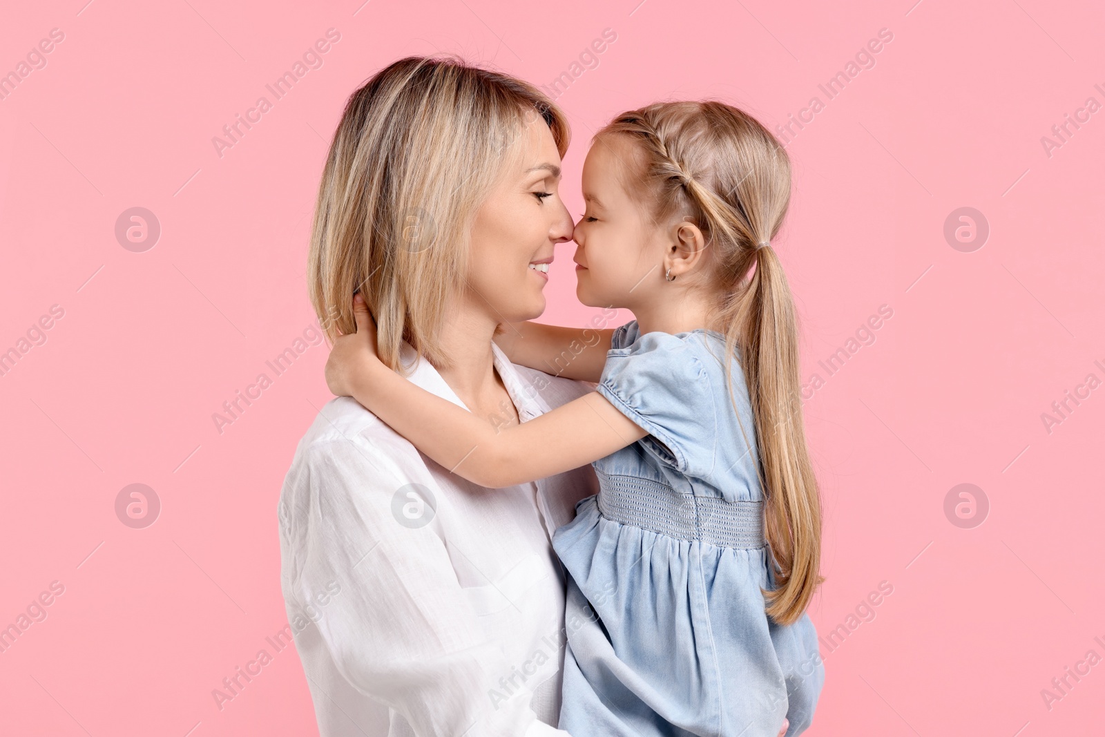 Photo of Family portrait of happy mother and daughter on pink background