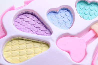 Photo of Decorative cosmetics for kids. Eye shadow palette with applicator as background, closeup