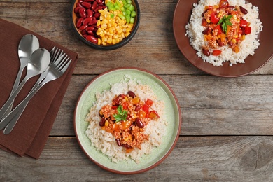 Chili con carne served with rice on wooden table, top view