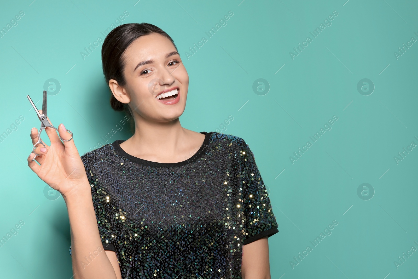 Photo of Professional hairdresser with scissors on color background