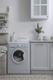 Kitchen interior with washing machine and stylish furniture