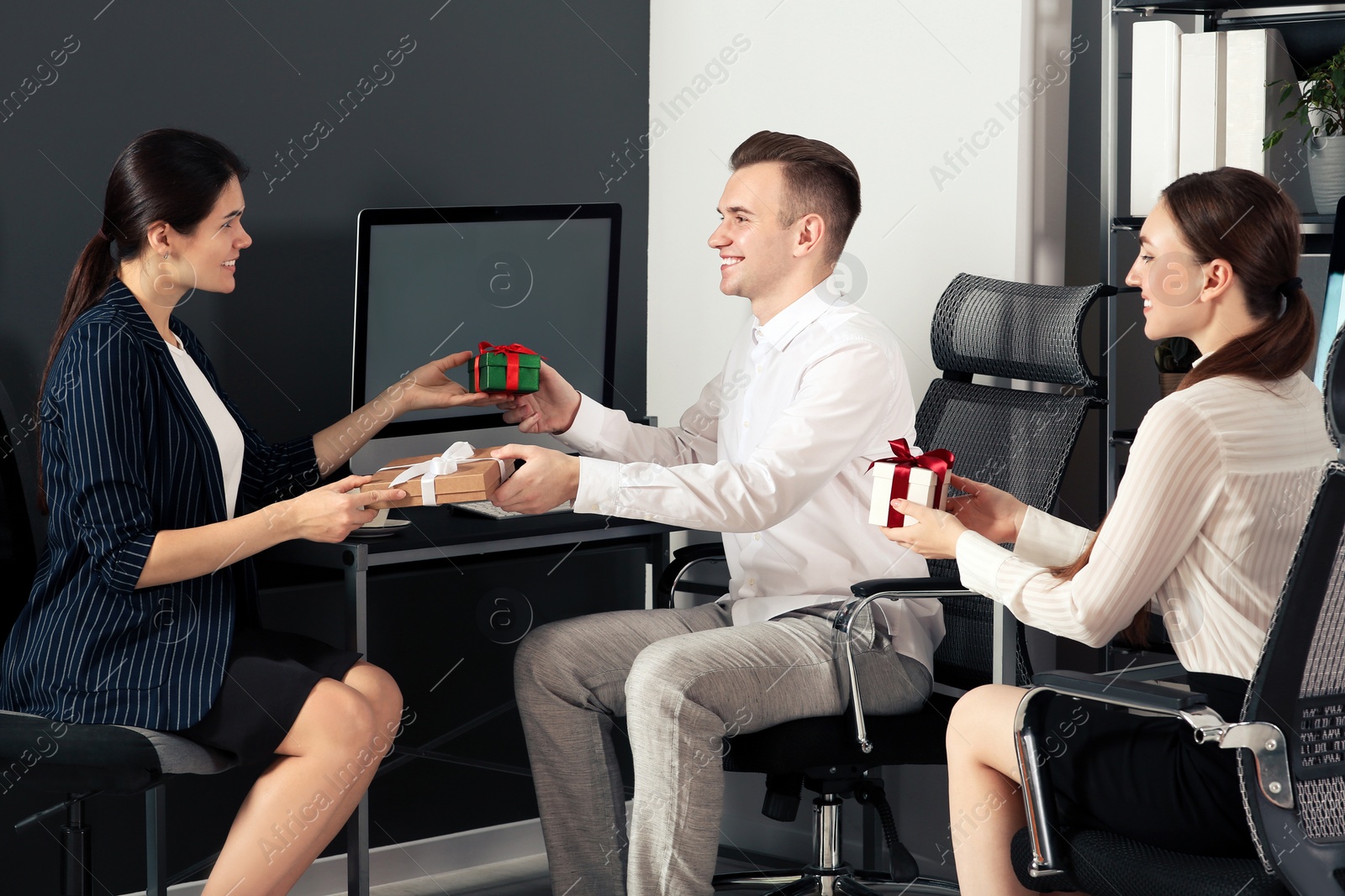 Photo of Colleagues presenting gifts each other in office