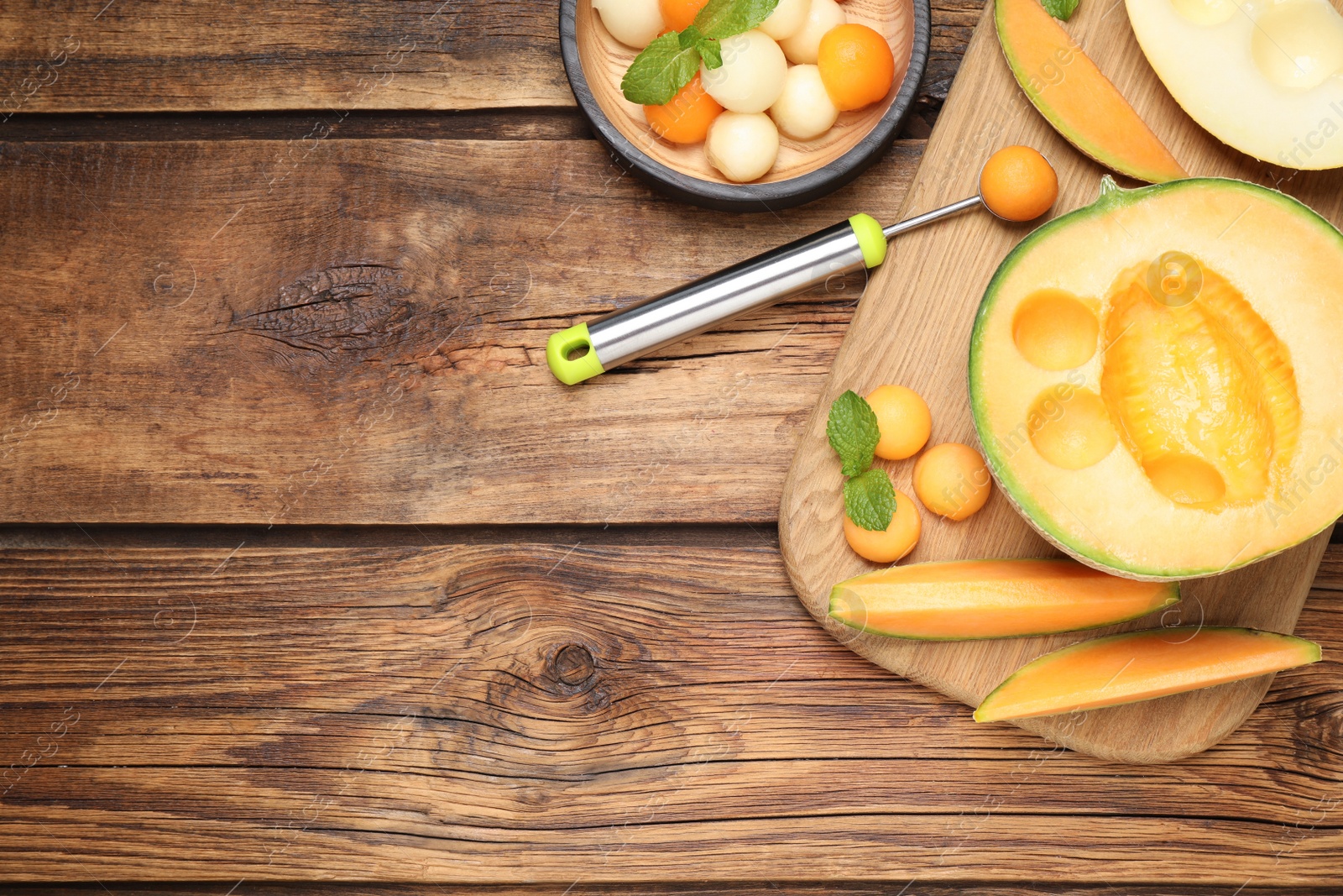 Photo of Flat lay composition with melon balls on wooden table, space for text