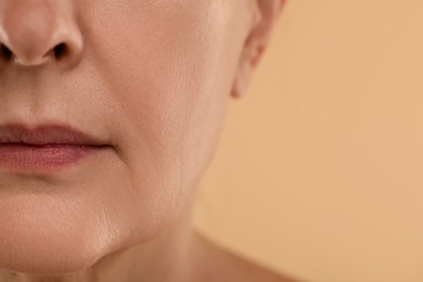 Woman with normal skin on beige background, macro view. Space for text