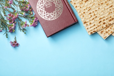Photo of Flat lay composition with matzo and Torah on color background, space for text. Passover (Pesach) Seder