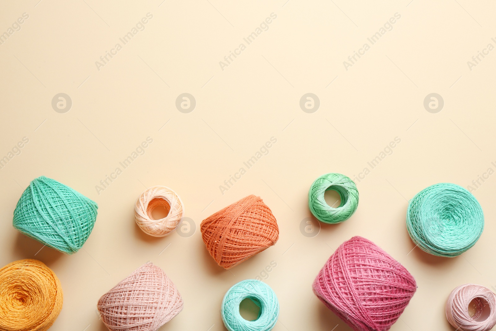 Photo of Clews of knitting threads on color background, flat lay with space for text. Sewing stuff