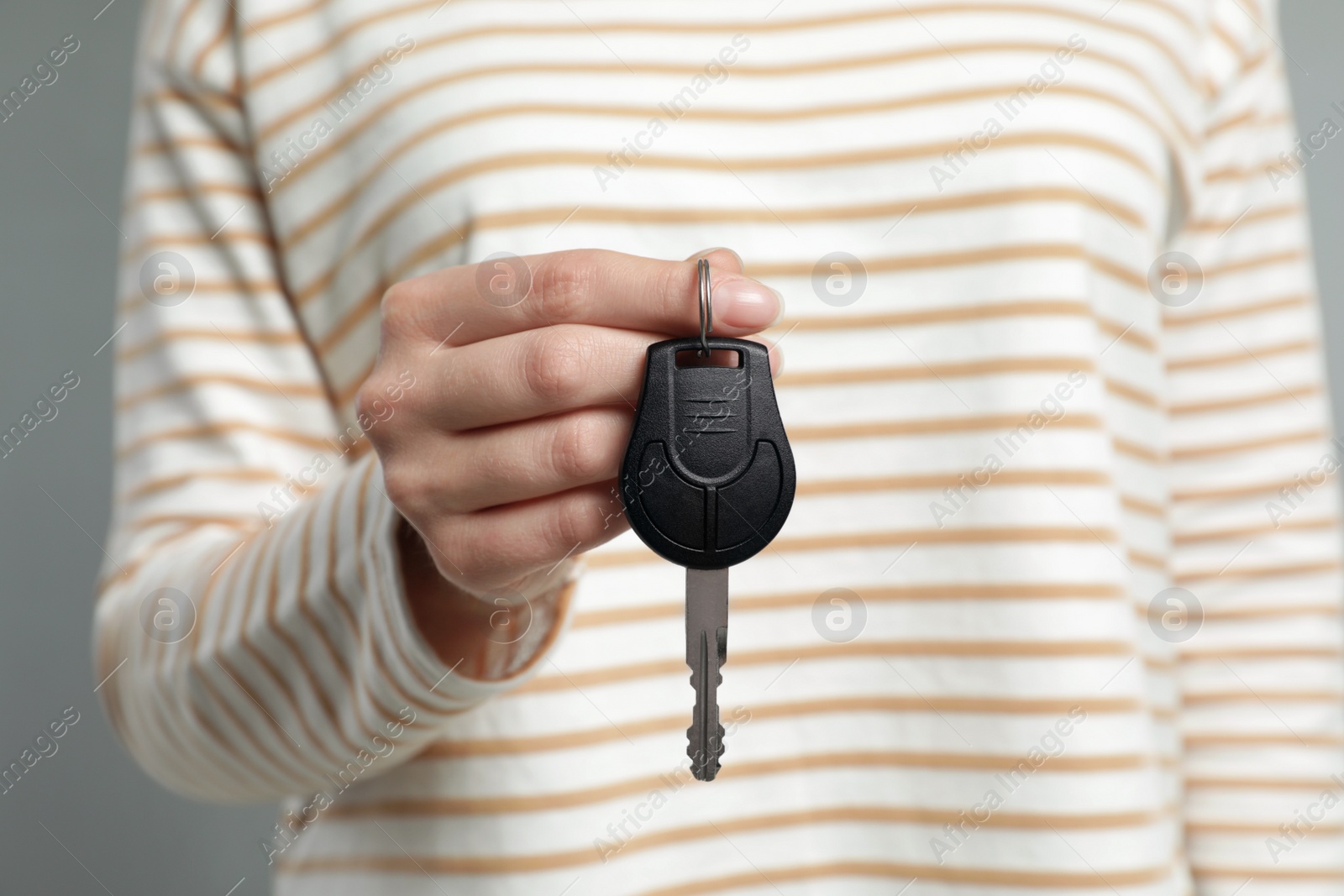 Photo of Young woman holding new car key, closeup