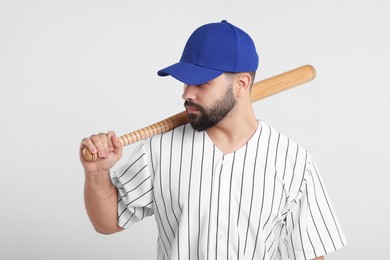 Photo of Man in stylish blue baseball cap holding bat on white background