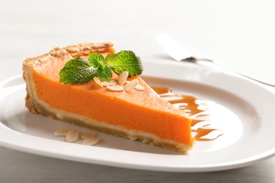 Photo of Plate with piece of fresh delicious homemade pumpkin pie on table, closeup