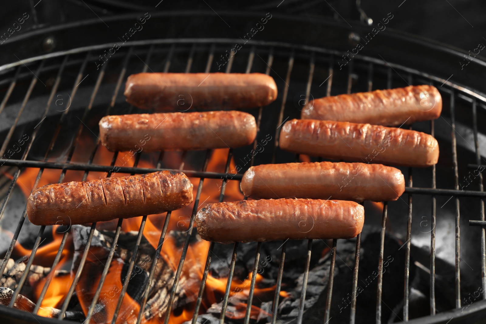 Photo of New modern barbecue grill with tasty sausages, closeup