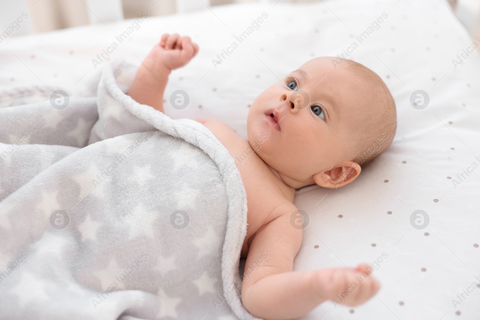 Photo of Cute little baby lying in crib at home