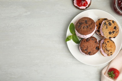 Photo of Sweet delicious ice cream cookie sandwiches served on table, flat lay. Space for text